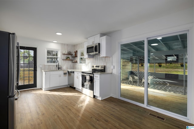 kitchen with white cabinetry, sink, tasteful backsplash, dark hardwood / wood-style floors, and appliances with stainless steel finishes