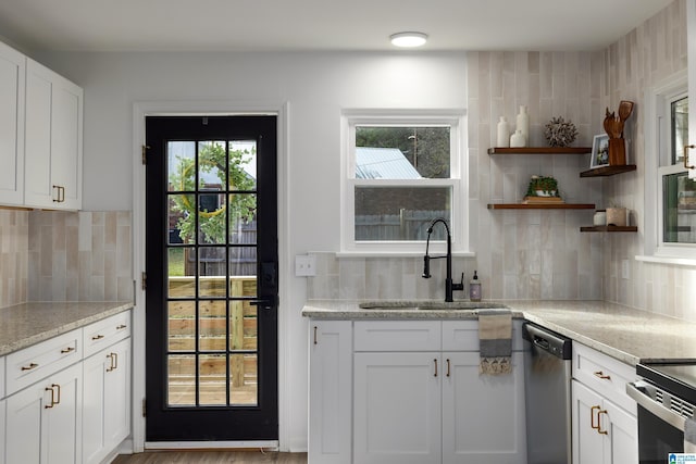 kitchen with white cabinets, sink, stainless steel dishwasher, decorative backsplash, and light stone countertops