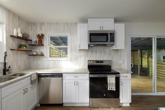 kitchen featuring white cabinets, sink, light stone countertops, tasteful backsplash, and stainless steel appliances