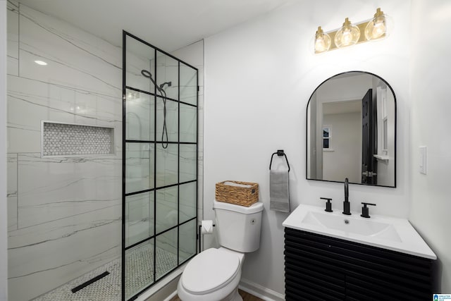 bathroom featuring tiled shower, vanity, and toilet