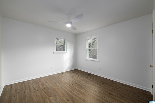 empty room with ceiling fan and dark wood-type flooring