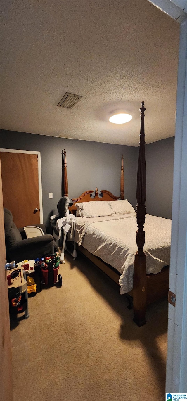 bedroom featuring carpet floors and a textured ceiling