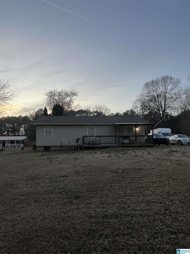 view of front of house featuring a lawn and a wooden deck