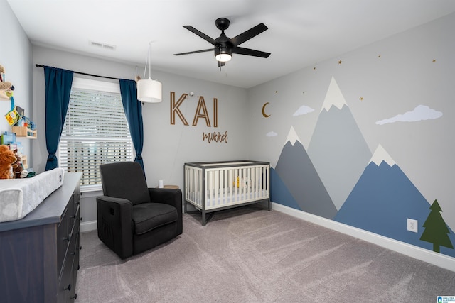 bedroom featuring carpet flooring, ceiling fan, and a crib