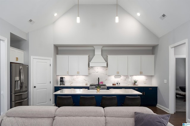 kitchen with white cabinetry, high vaulted ceiling, premium range hood, pendant lighting, and appliances with stainless steel finishes