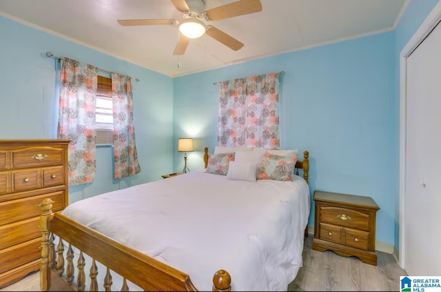 bedroom with ceiling fan, light hardwood / wood-style floors, and a closet