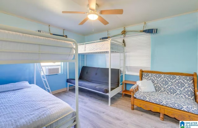 bedroom featuring hardwood / wood-style floors, ceiling fan, and cooling unit