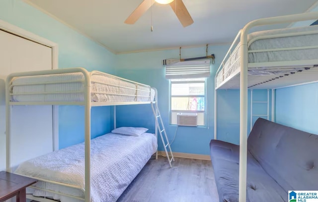 bedroom with hardwood / wood-style flooring, crown molding, ceiling fan, and cooling unit