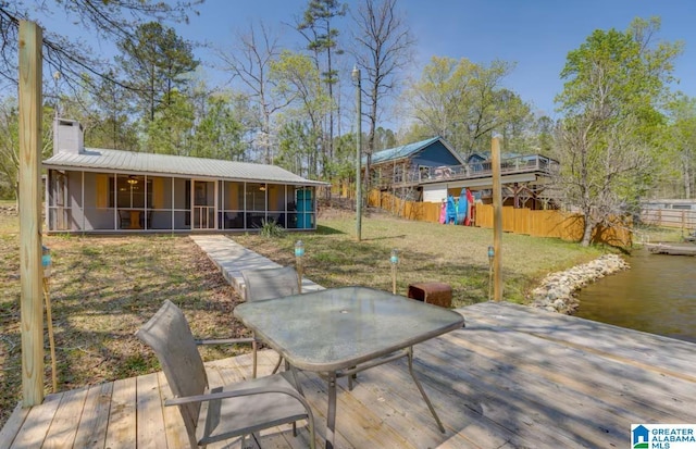 exterior space featuring a lawn, a sunroom, a playground, and a water view