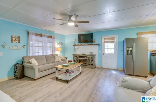 living room with a drop ceiling, light hardwood / wood-style flooring, and ceiling fan