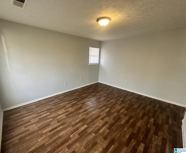 unfurnished room with a textured ceiling and dark hardwood / wood-style floors