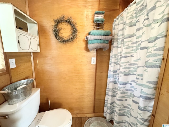 bathroom with wooden walls and toilet