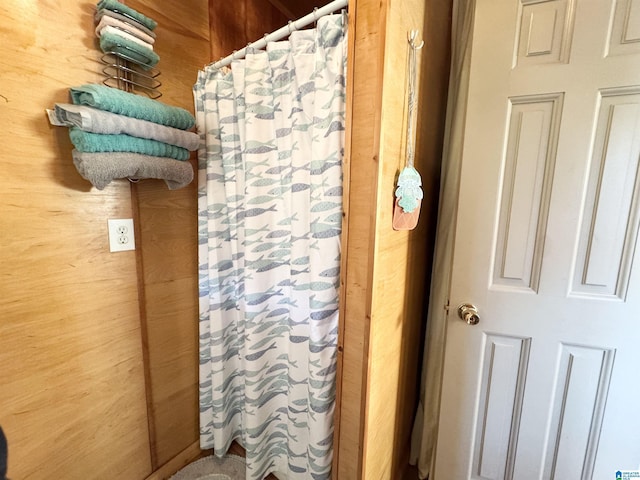 bathroom featuring wood walls