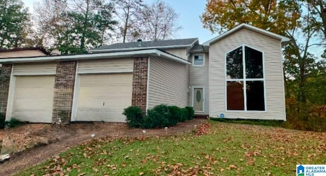 rear view of property with a lawn and a garage