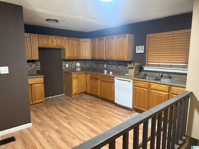 kitchen featuring light hardwood / wood-style floors, dishwasher, backsplash, and sink