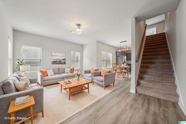 living room featuring wood-type flooring and an inviting chandelier