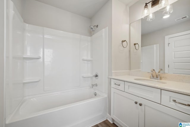 bathroom with hardwood / wood-style flooring, vanity, and  shower combination