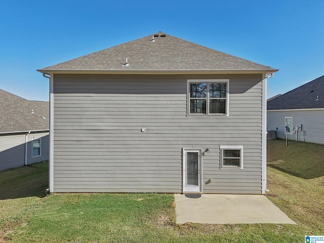 rear view of property featuring a lawn and a patio