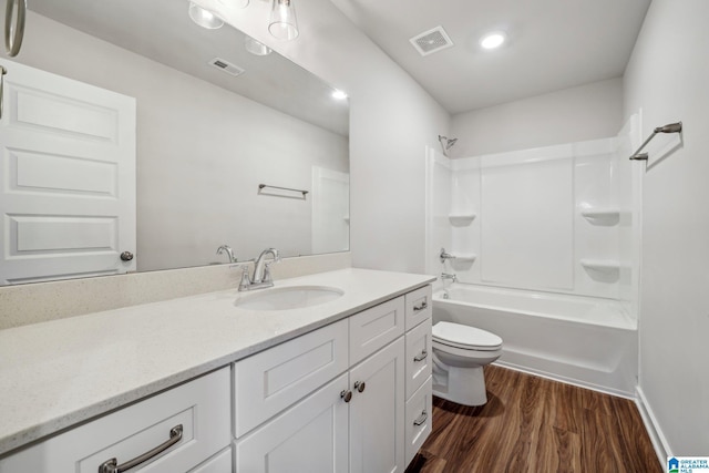 full bathroom featuring hardwood / wood-style floors, vanity, toilet, and bathing tub / shower combination