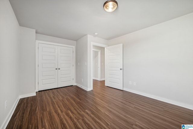 unfurnished bedroom featuring a closet and dark wood-type flooring