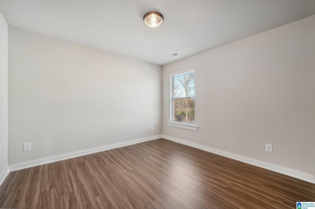 unfurnished room with dark wood-type flooring