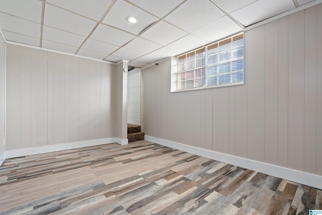 basement with a drop ceiling and hardwood / wood-style floors