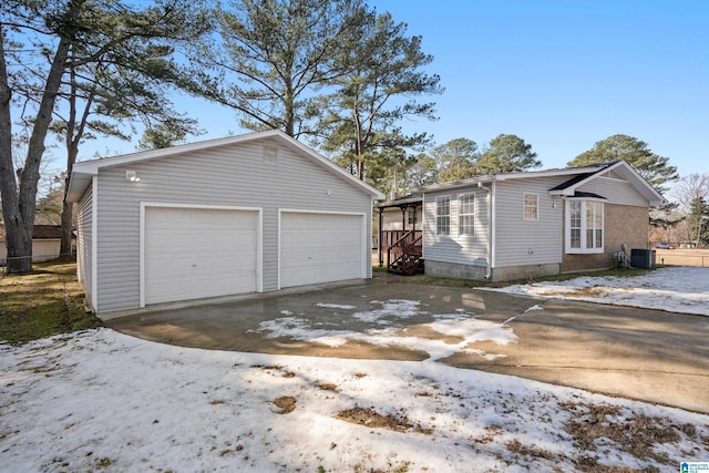 exterior space with a garage, central AC, and an outbuilding