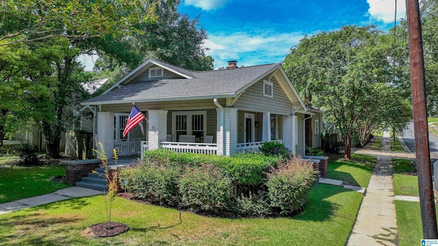 bungalow featuring a porch and a front lawn