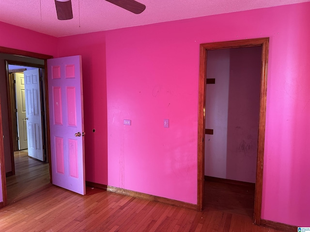 unfurnished bedroom with a textured ceiling, ceiling fan, and hardwood / wood-style floors