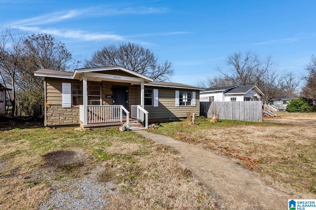 view of front of home with covered porch and a front lawn