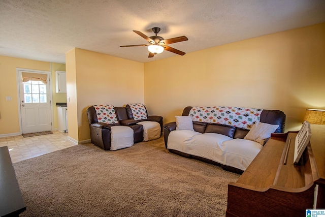 living room featuring light carpet, a textured ceiling, and ceiling fan