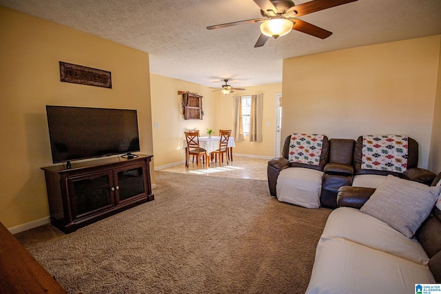 living room featuring a textured ceiling, ceiling fan, and carpet