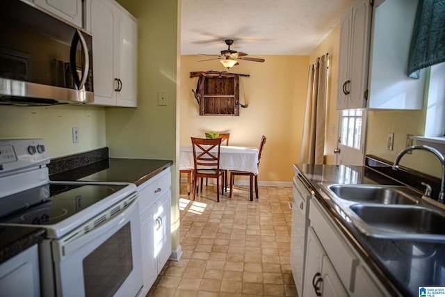 kitchen featuring white appliances, ceiling fan, a textured ceiling, white cabinetry, and sink