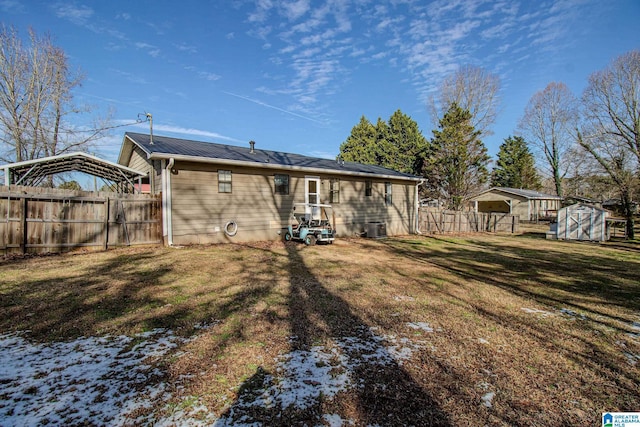 rear view of house with central AC and a lawn