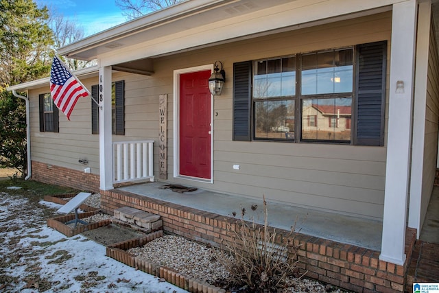 snow covered property entrance featuring covered porch