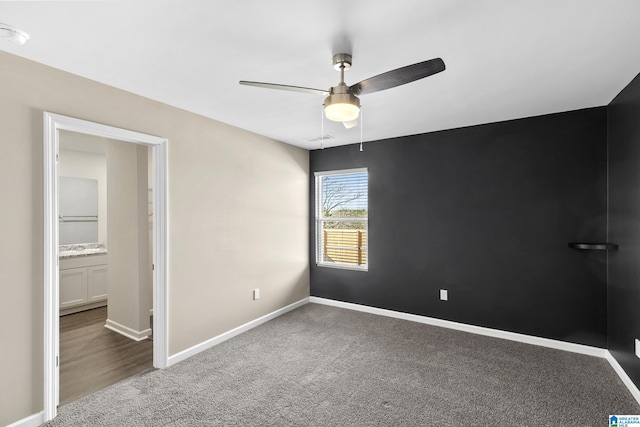 carpeted spare room featuring ceiling fan