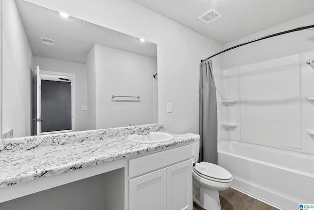 full bathroom featuring hardwood / wood-style floors, toilet, vanity, and shower / bath combo