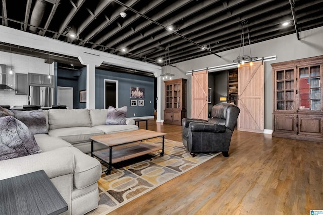 living room with hardwood / wood-style flooring and a barn door