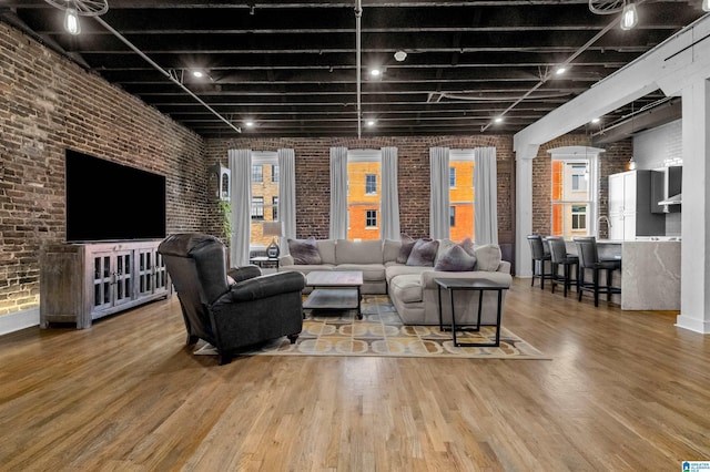 living room featuring brick wall and hardwood / wood-style floors