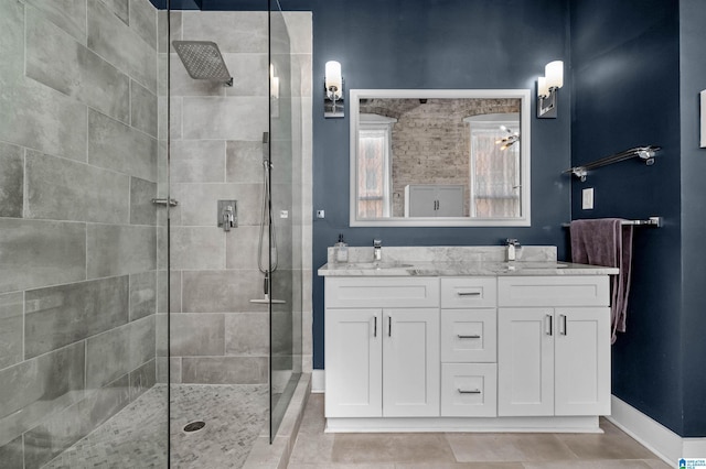 bathroom featuring vanity, tile patterned floors, and a tile shower