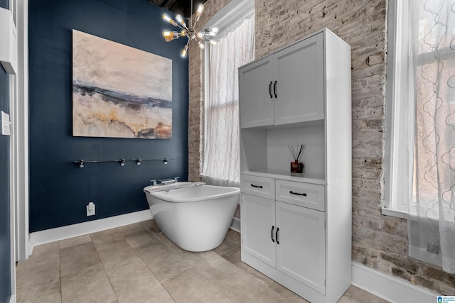 bathroom with a bath, tile patterned floors, and a notable chandelier