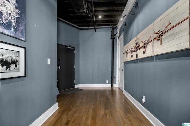 corridor featuring a high ceiling and hardwood / wood-style flooring