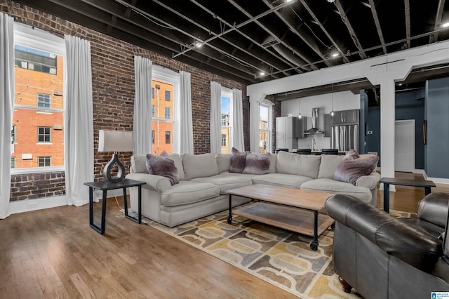 living room with brick wall and wood-type flooring