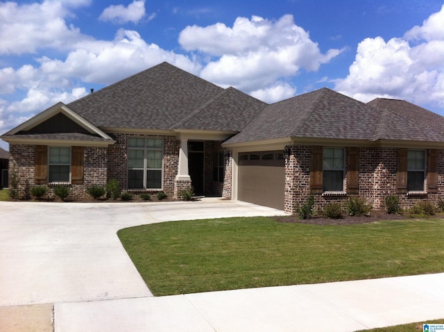 view of front of house featuring a front lawn and a garage