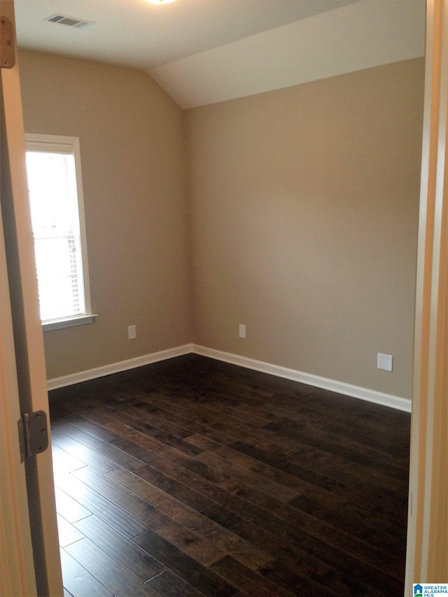 empty room with lofted ceiling and dark hardwood / wood-style floors