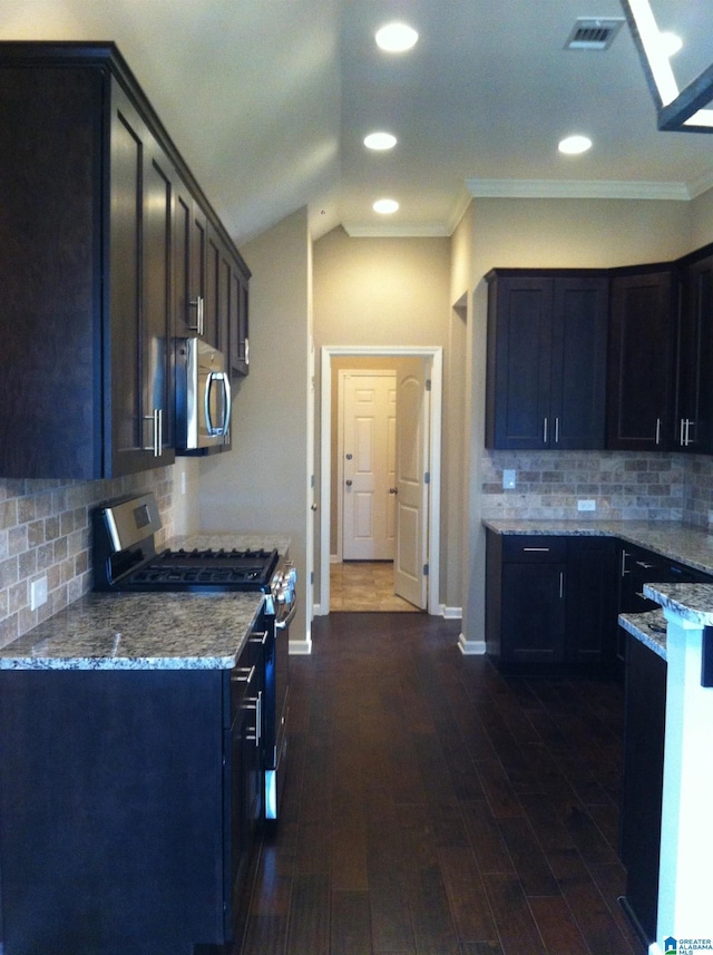 kitchen featuring light stone counters, ornamental molding, backsplash, dark hardwood / wood-style flooring, and appliances with stainless steel finishes