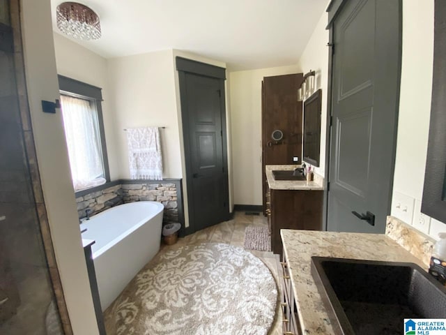 bathroom with a bath, tile patterned flooring, and vanity