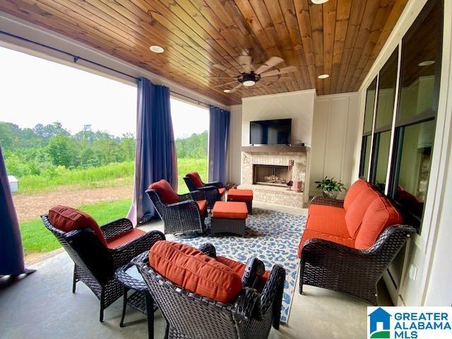 view of patio featuring an outdoor fireplace and ceiling fan