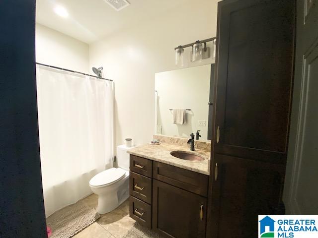 full bathroom with vanity, tile patterned flooring, toilet, and shower / tub combo with curtain