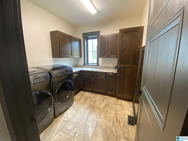 laundry room featuring washer and dryer and cabinets